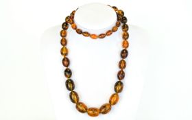 Long Amber Style Necklace, graduating oval beads of a reconstituted resin or similar composition,