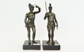 Two Bronze Figures In The Form Of Roman Gladiators Each raised on square ebonised wood base.