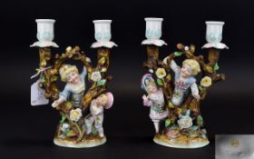 Conta and Boehme Pair of Double Candlesticks, each showing two children playing amongst trees,