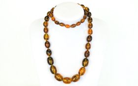 Long Amber Style Necklace, graduating oval beads of a reconstituted resin or similar composition,