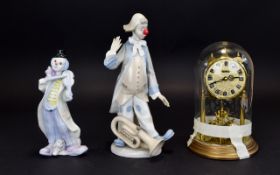 A Pair Of Ceramic Clown Figures Two in total, the first with raised hand and trombone at feet.
