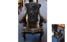 A Reproduction Ebonised Wood Oriental Style Throne Chair Features ornate carving throughout,