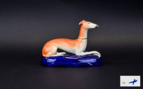 Staffordshire 19th Century Figure of a Recumbent Whippet on a Shaped and Scrolled Painted Blue Base.