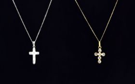 Two Gold Crucifix Pendant and Chain Necklaces comprising one white and one yellow gold.