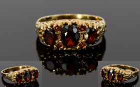 9ct Gold Garnet 3 Stone Ring, 4 smaller garnets set between the larger ones in a pretty mount.