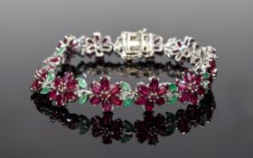Ruby and Emerald Flower Line Bracelet, each flower comprising six oval cut rubies around a central