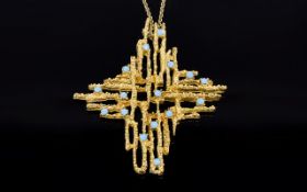 A Vintage 1970's Statement Pendant Gold tone pendant in the form of an exploded cross with textured