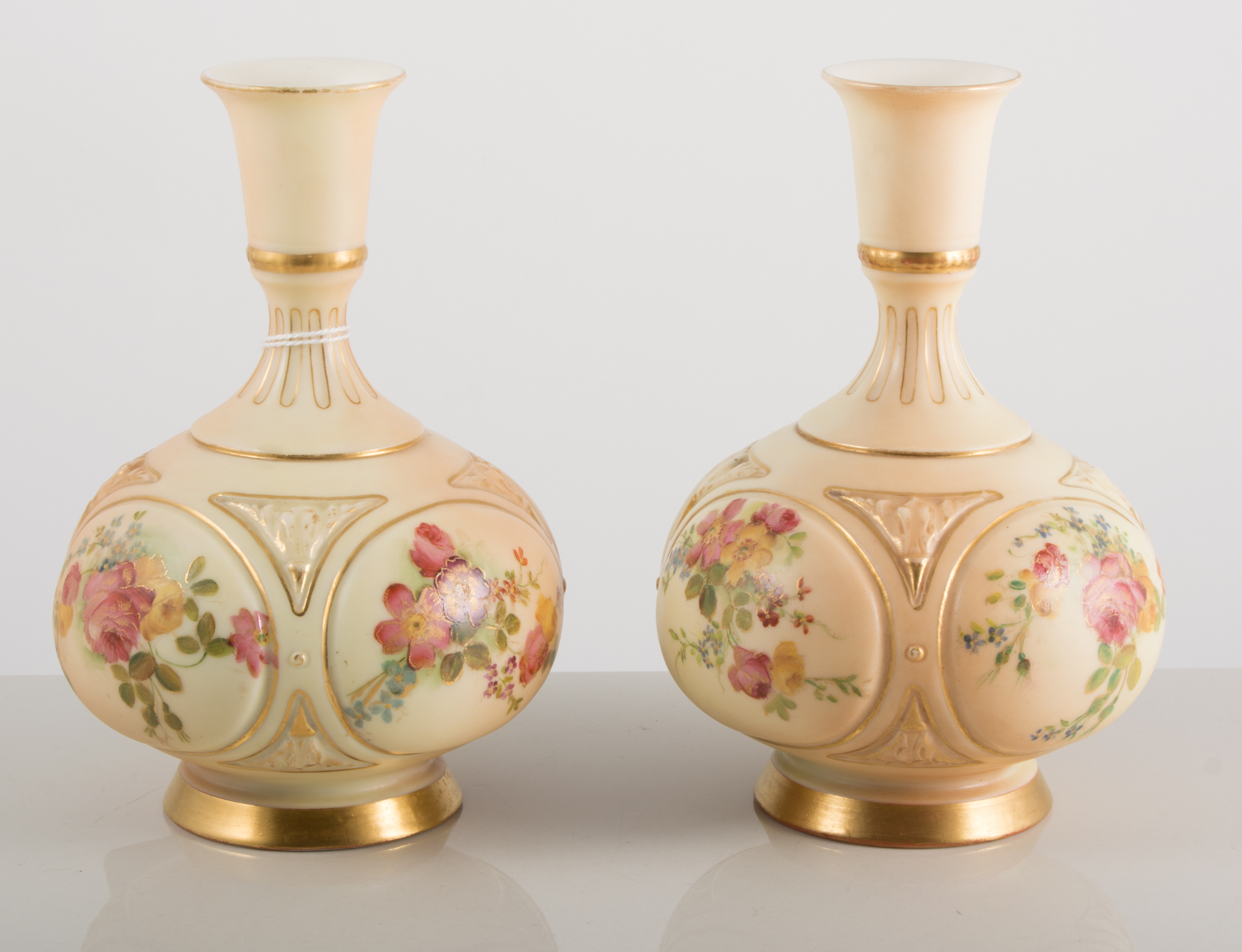 Pair of Royal Worcester bottle vases, the fields painted with roses and primulas,