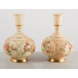 Pair of Royal Worcester bottle vases, the fields painted with roses and primulas,