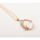 A cameo "spinner" pendant and chain, the oval carved shell cameo of a female profile 25m x 17mm,