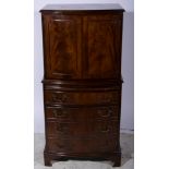 Reproduction mahogany small cocktail cabinet, bow-front form, the top with a moulded edge,