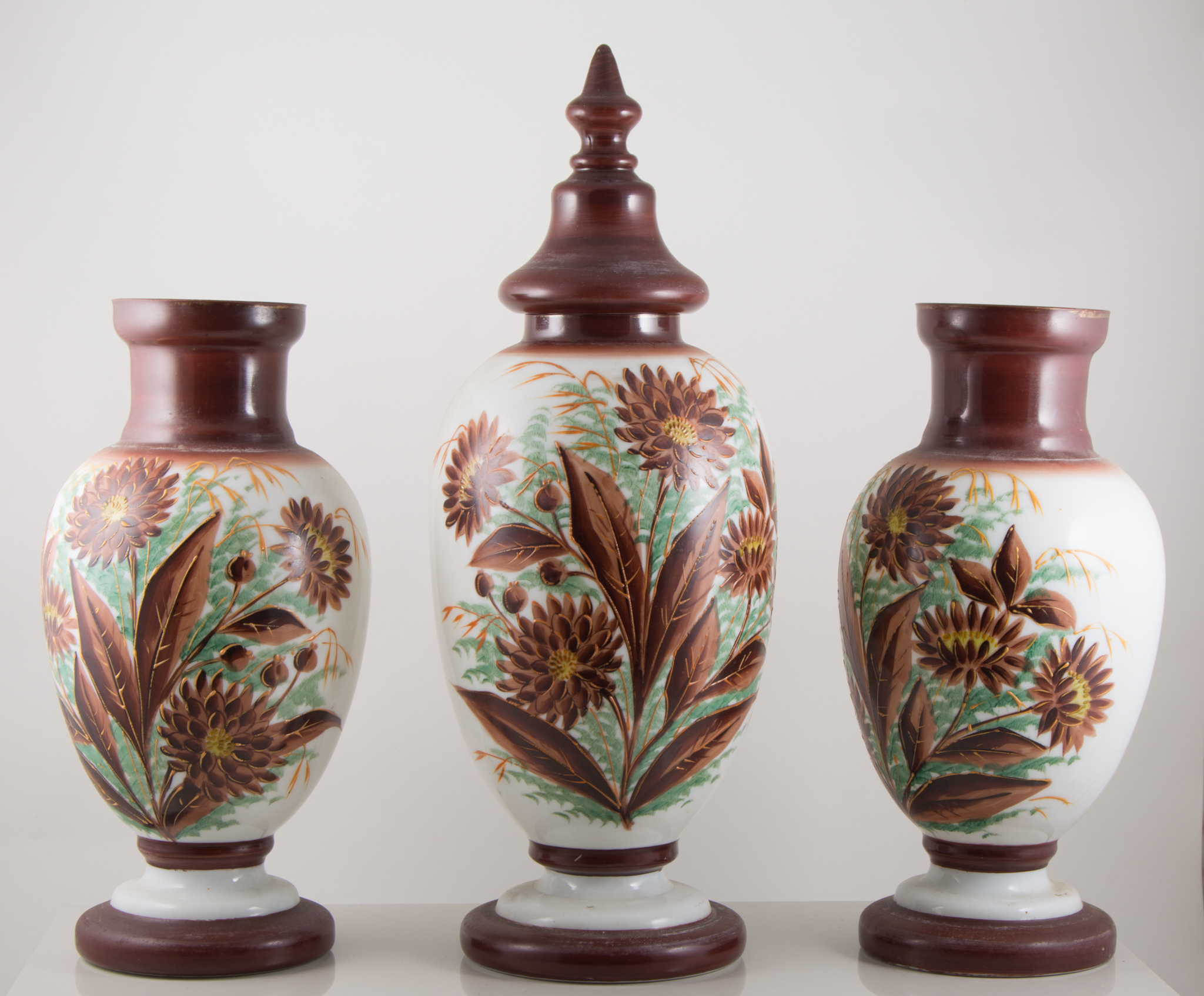 Garniture of three opaque glass vases, late 19th century, ovoid form, one with cover,