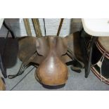 Two old leather saddles with large box of straps etc.