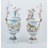 Pair of continental ewers, moulded with putti, the handles each a faun, 38cm.