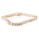 An all yellow metal diamond set tennis design bracelet, forty-two brilliant cut diamonds,