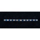 A sapphire and diamond white metal bar brooch,