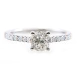 A diamond solitaire ring, the old brilliant cut stone four claw set in an all white metal mount,