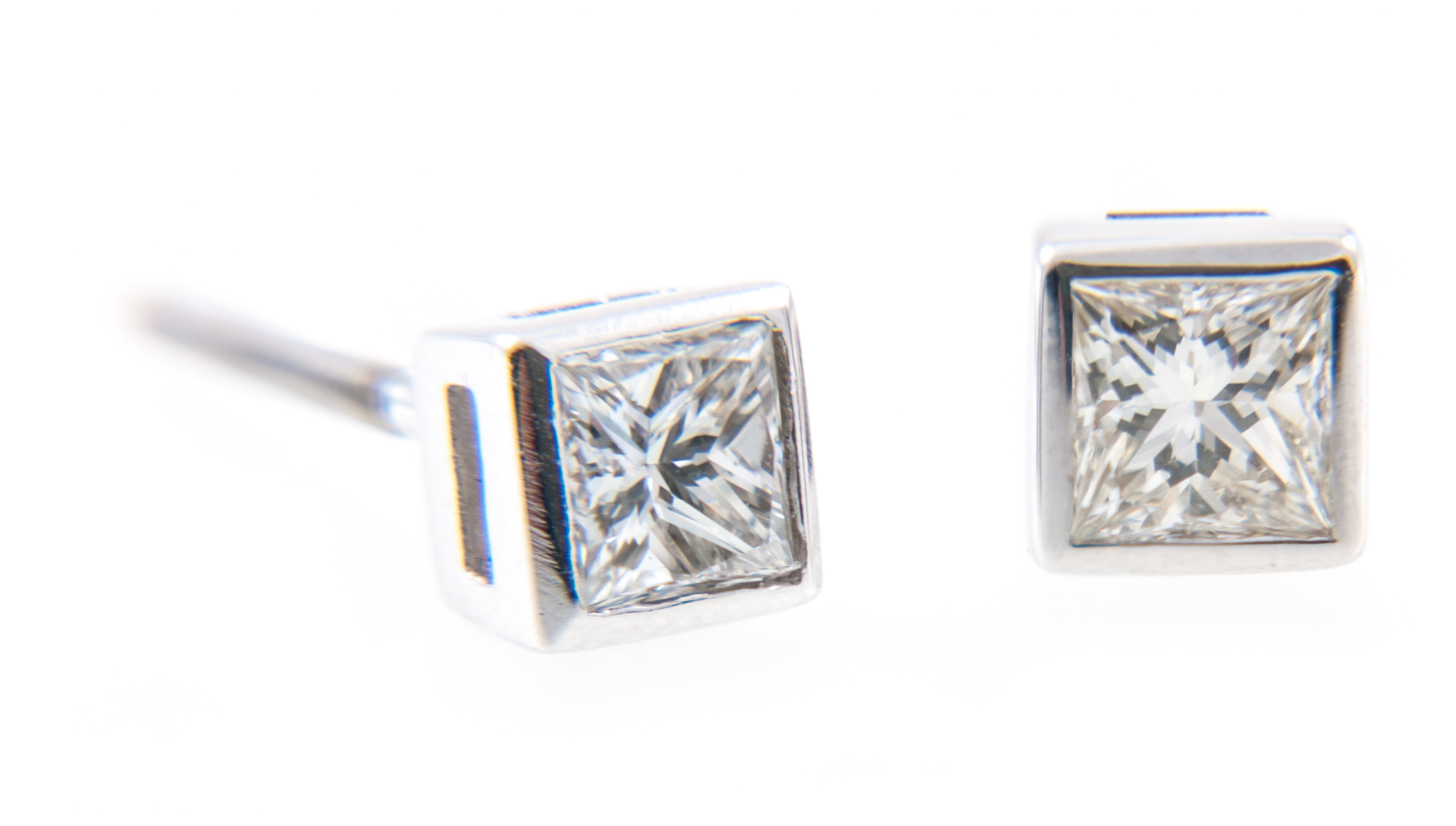 A pair of diamond single stone earrings, one princess cut diamond square set to each,