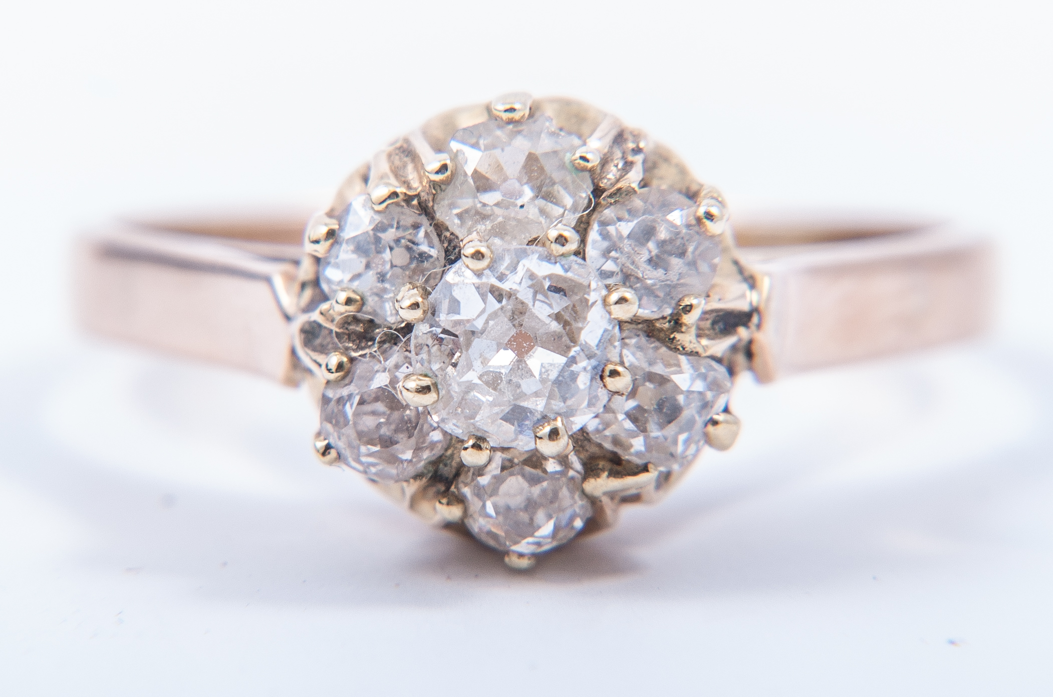 A diamond circular cluster ring, seven old brilliant cut diamonds,