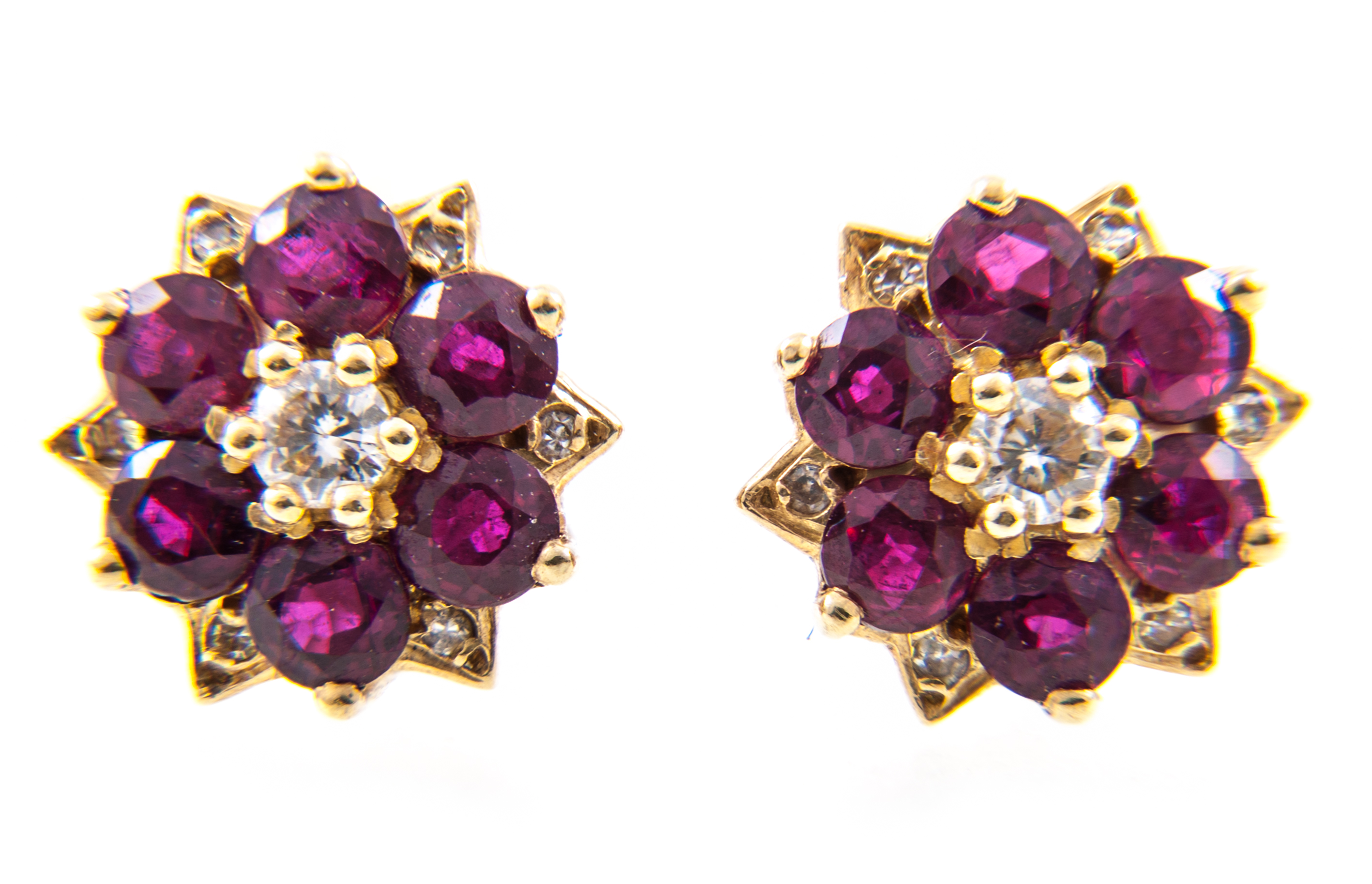 A pair of ruby and diamond circular cluster earrings, six rubies spaced by six,