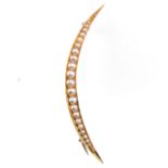 A seed pearl yellow metal open crescent brooch set with twenty-one pearls graduating in size,