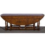 A joined oak wake table, 20th Century, oval top with two fall leaves,