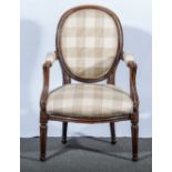 A French beechwood fauteuil, upholstered in check pattern cotton, moulded hoop back, open arms,