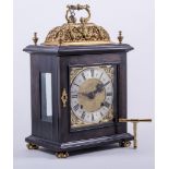 A Charles II style ebony and ebonised bracket clock, gilt metal 'casing' and 'basket' top,