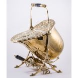 A late Victorian brass coal scuttle, helmet shape with a neo-classical embossed top,