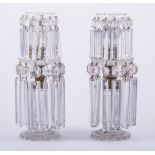 A pair of Regency cut glass two-tier candlesticks, each with faceted and prismatic drops,