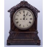 A mahogany bracket clock, carved cresting to the case, circular dial with Roman numerals,
