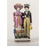 A Pearl glazed earthenware Dandies group, he with a basket, she with a parasol, square base,