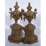 A pair of cast brass urn shape chenets in the style of Robert Adam, swagged urns on fluted plinths,
