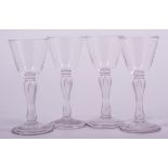A set of four wine glasses, mid 18th century design, rounded funnel bowl, teardrop baluster stems,