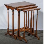 A nest of three painted satinwood occasional tables, in the George III style, serpentine outlines,