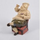 A glazed pottery figure of a portly gentleman, seated and holding a pint of beer and cigar,