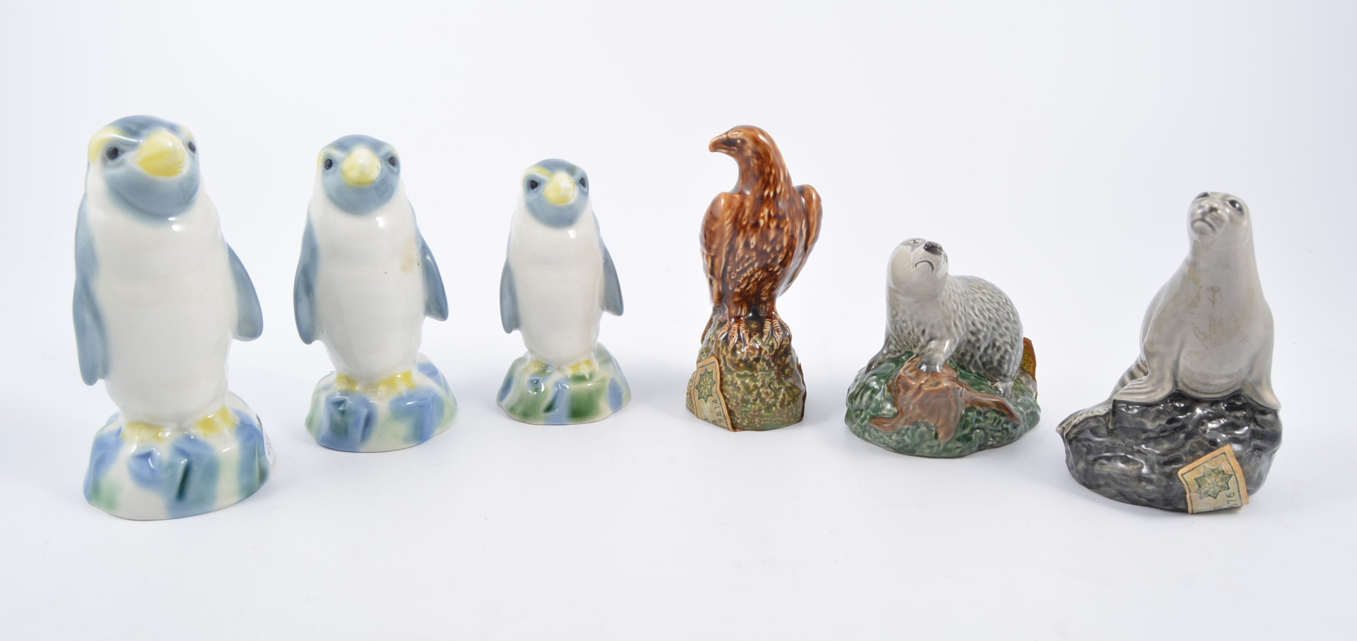 Beswick and Wade whisky flasks, three Wade Penguins with stoppers, Beswick Eagle no.