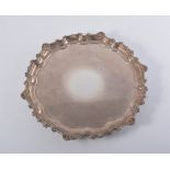 A chippendale style silver salver, shell and scroll border, on three scroll feet, plain base,