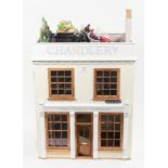 Dolls house of a shop front with greenhouse, quantity furniture and models, 48cm wide, 32cm deep,