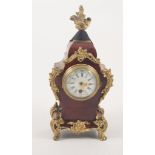 A small tortoiseshell mantel clock with gilded mounts,