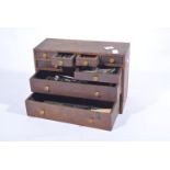 Small set of wooden bench top drawers containing engineering tools.