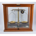 A set of precision balance scales, by Griffin and George Ltd, glazed case,