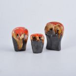 Eric Leaper, three pottery owl models, running burnished orange glaze over a manganese body, 7cm, 8.
