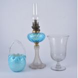 Collection of coloured glass jugs, pedestal oil lamp, and celery vase.