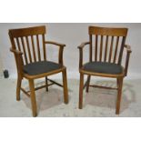 Pair of oak elbow chairs, broad cresting slat backs, upholstered seats, legs joined by rails,