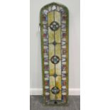 A Victorian stained glass window, elongated with arched top, in original window frame, 148cm high,