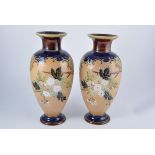 Doulton Lambeth, a pair of stoneware vases, the textured ground tubelined with blossom on branches,