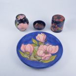 Walter Moorcroft, 'Magnolia' a blue ground plate, 26cm; a 'Magnolia' ginger jar, 11cm; 'Anemone',
