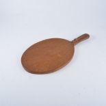 Robert "Mouseman" Thompson of Kilburn, an adzed oak cheeseboard, oval with handle,