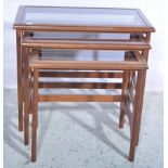 Nest of three teak tables, smoked glass inserts,